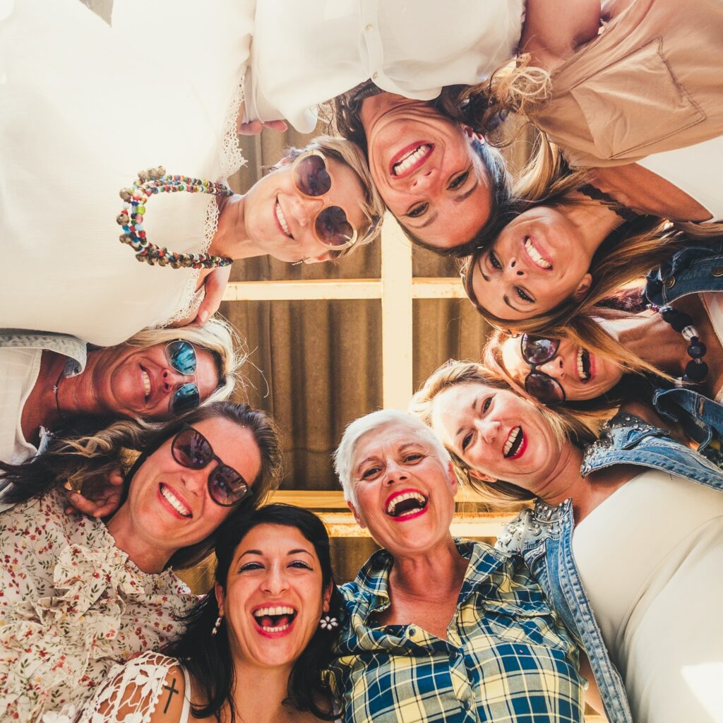 Cheerful group of nine beautiful women enjoying the party in the terrace looking down at the camera